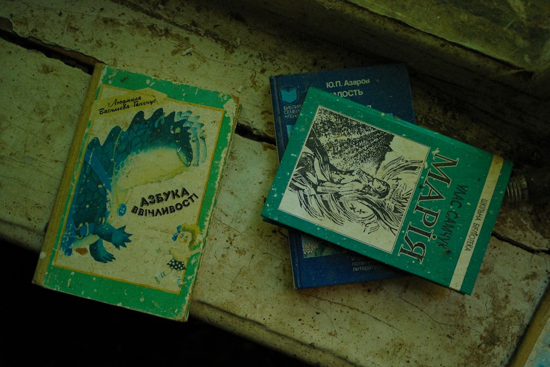 Three old books resting on a wooden surface.