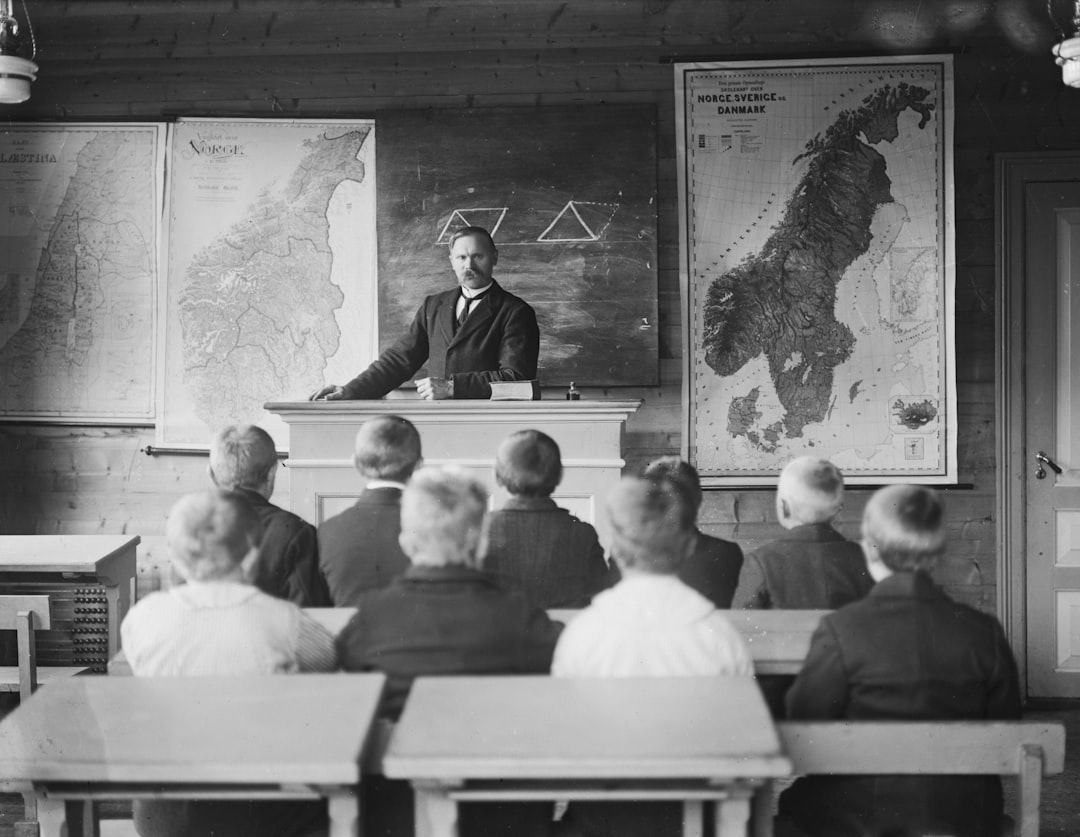 Teacher instructing students in a classroom with maps.