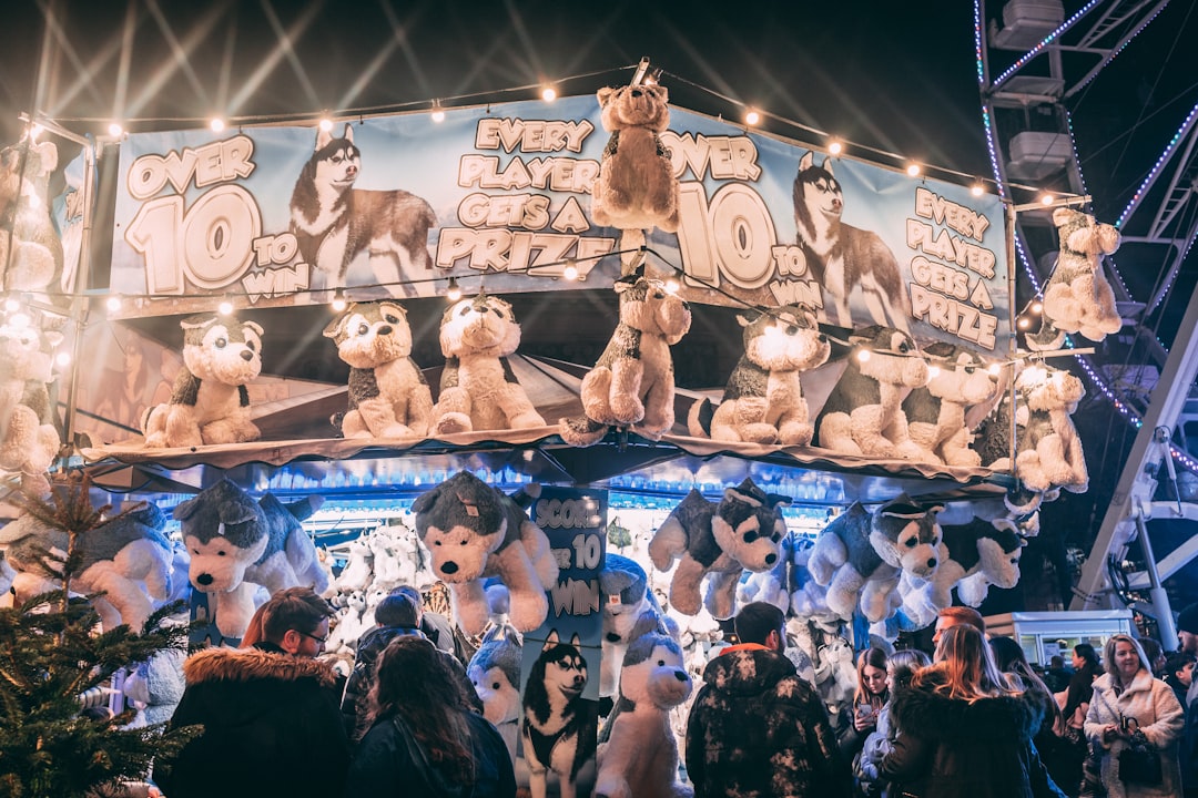 a crowd of people standing around a carnival booth