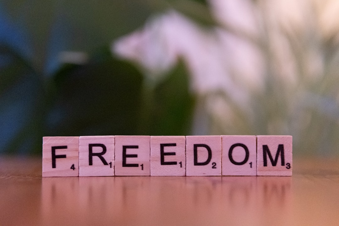 A wooden block spelling the word freedom on a table