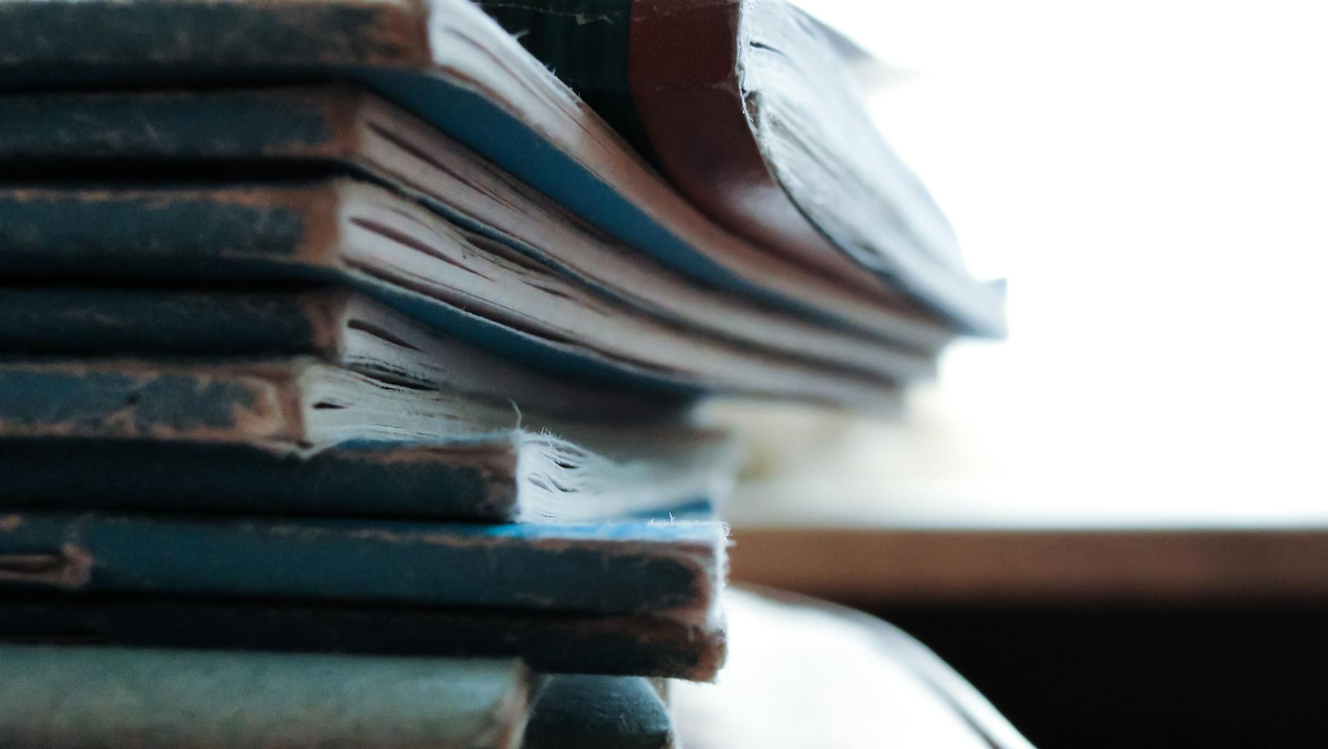 Artistic close-up of a stack of worn out notebooks with a vintage feel.