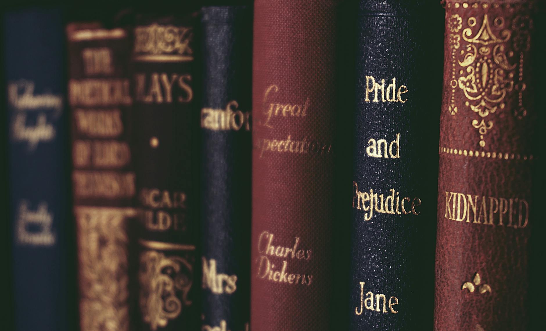 Vintage classic literature books lined up neatly on a bookshelf