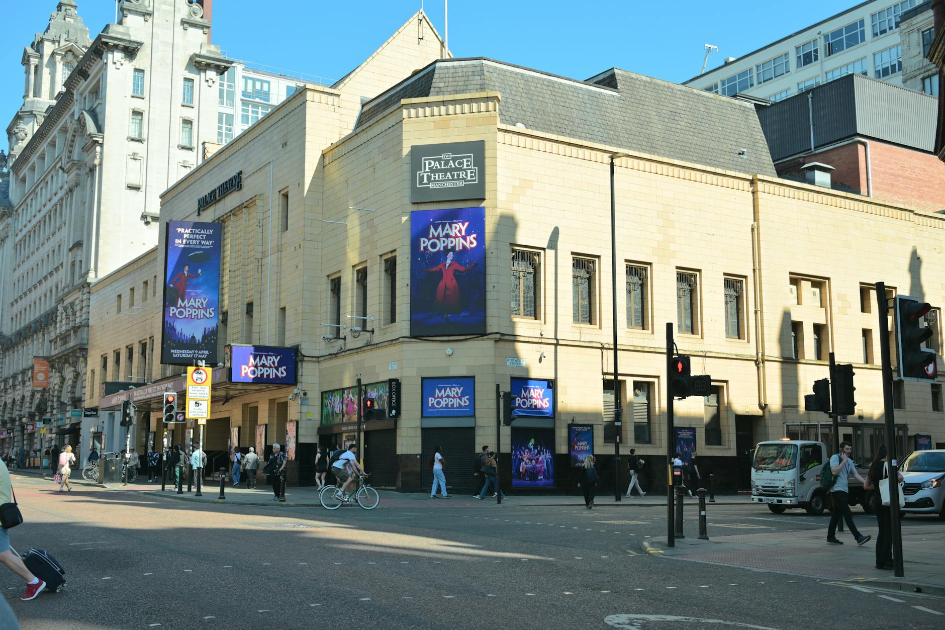 Palace Theatre in Manchester, UK, showcasing Mary Poppins posters on a sunny day.