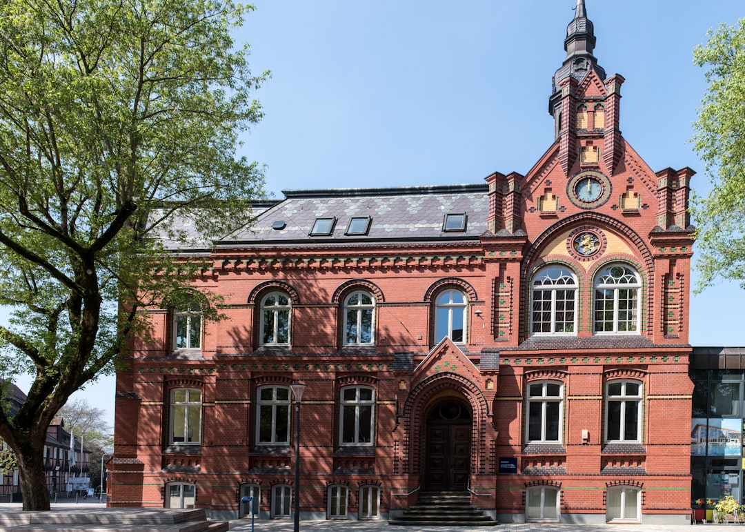 A brick building stands beneath a clear, blue sky.